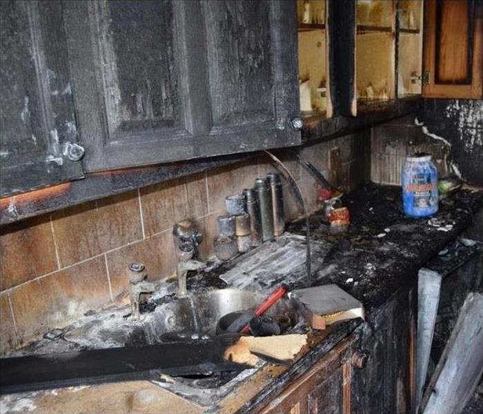 Kitchen with fire damage and soot.